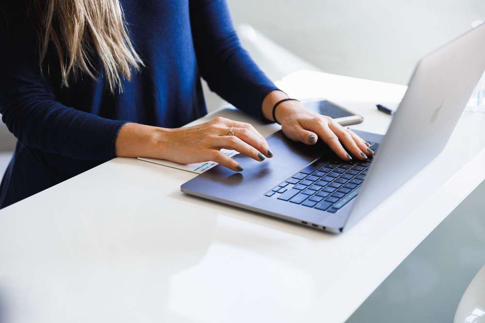 Periodista con dos manos sobre el teclado de una computadora portátil. Fotografía de Luke Southbern en Unsplash